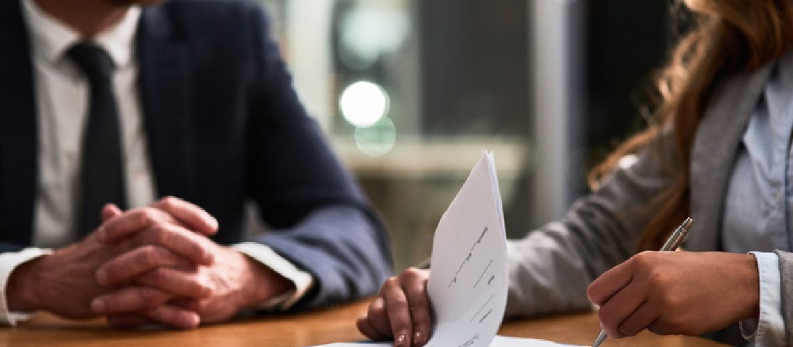 Cropped shot of a businessman and businesswoman completing paperwork together at a desk